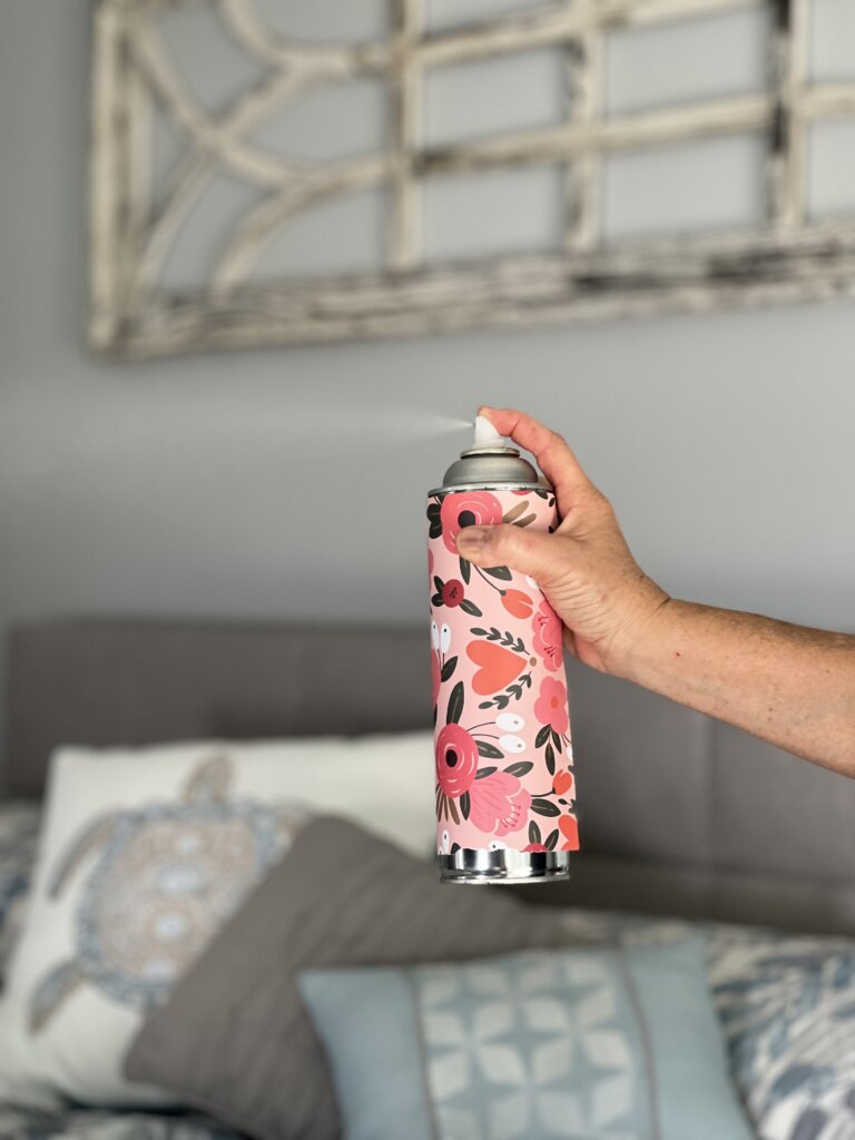 a can of aerosol air freshener being sprayed