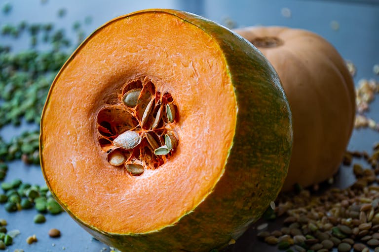 a pumpkin sliced to show seeds and stringy guts