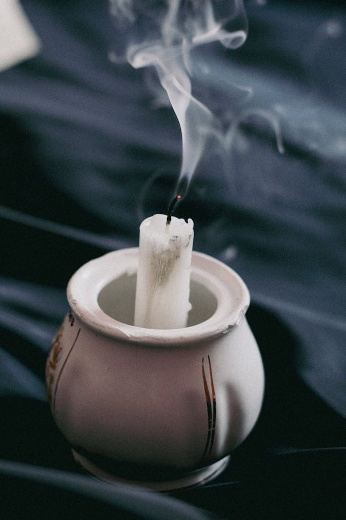 Photo of a White Candle in a Porcelain Dish with smoke 