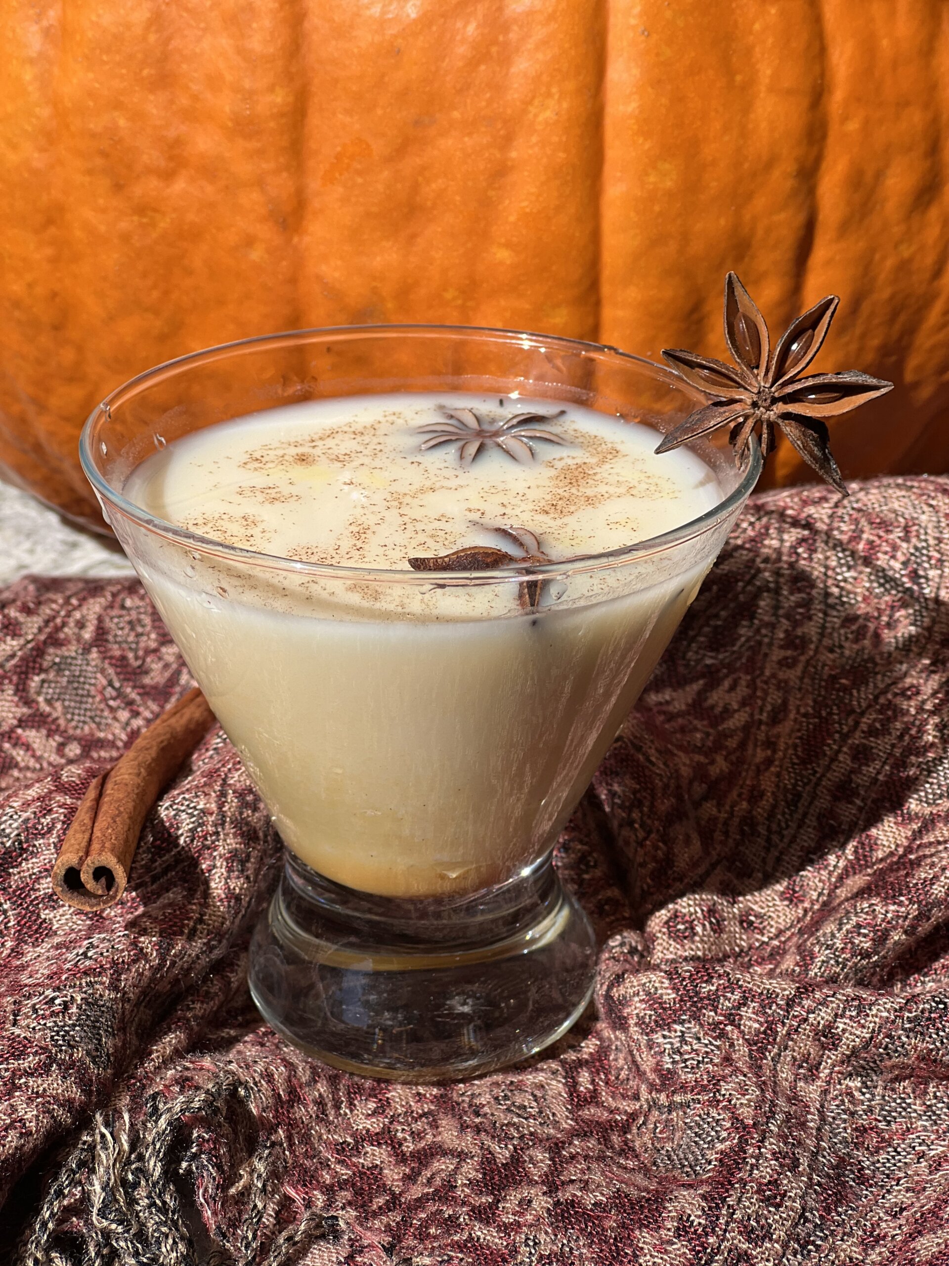 pumpkin chai tea in a stemless martini glass with star anise garnish