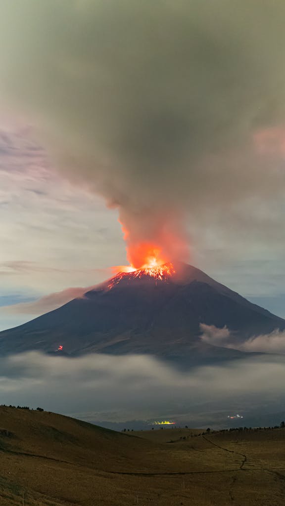 Dramatic eruption of Popocatépetl Volcano in Mexico at dusk, with fiery lava and smoke.